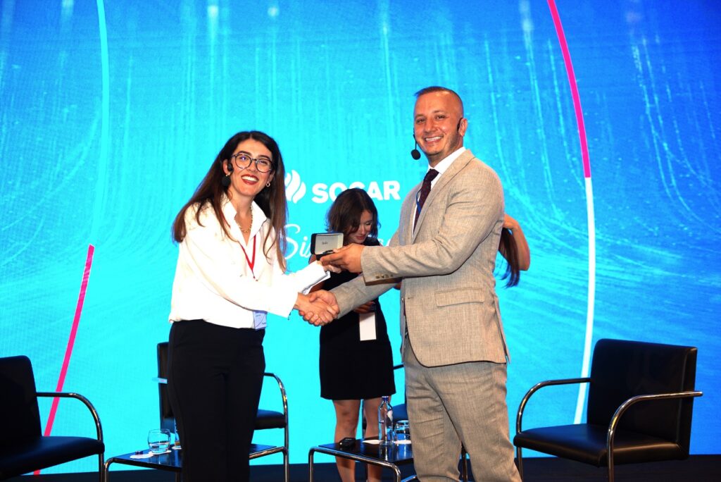 A man and woman shaking hands at a business event.