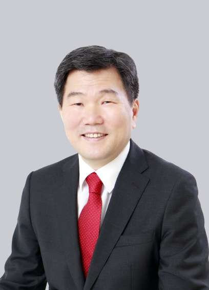 An asian man in a suit and red tie.