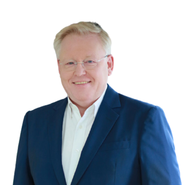 A man with blonde hair, wearing glasses, a white shirt, and a blue suit jacket, smiles at the camera.