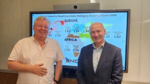 Two men stand in front of a screen displaying a map with smart industry readiness ratings for 2024.