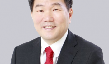An asian man in a suit and red tie.