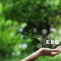 A hand holding a digital hologram of ESG (environmental, social, and governance) icons, set against a lush green forest background.